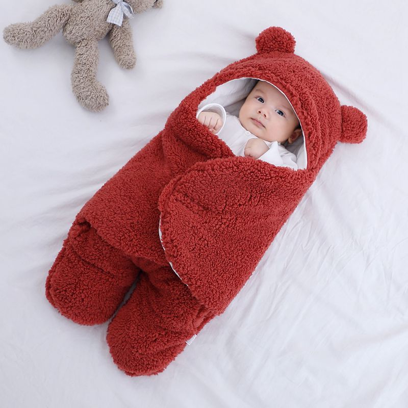 Baby i sovepose med bjørneører