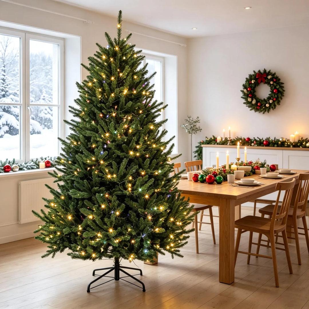 Fyldig grønt juletre med lys og fotbryter
