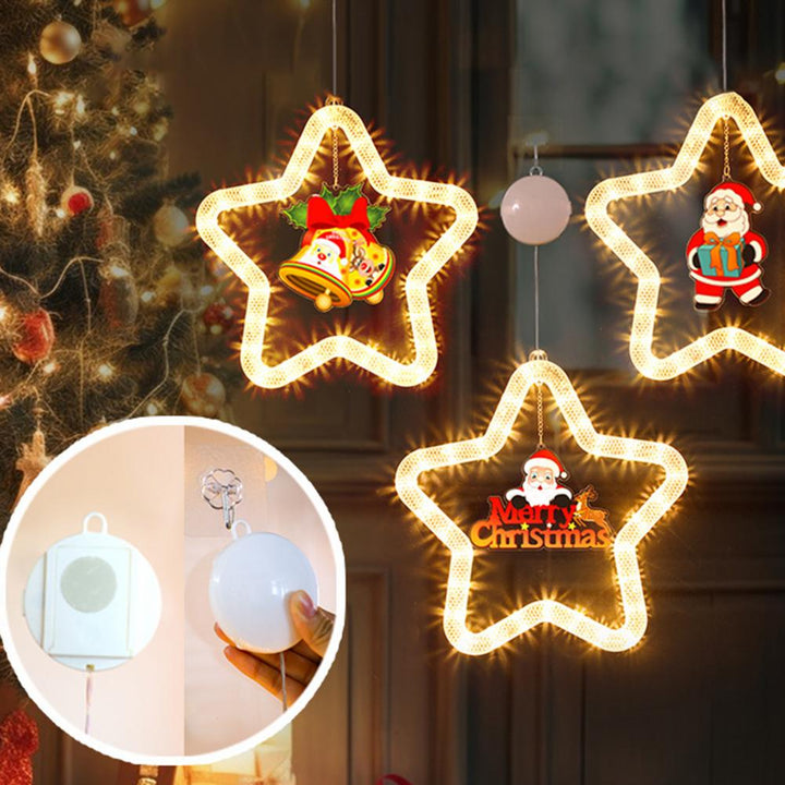Lysende LED-stjerne med julemotiv i vindu