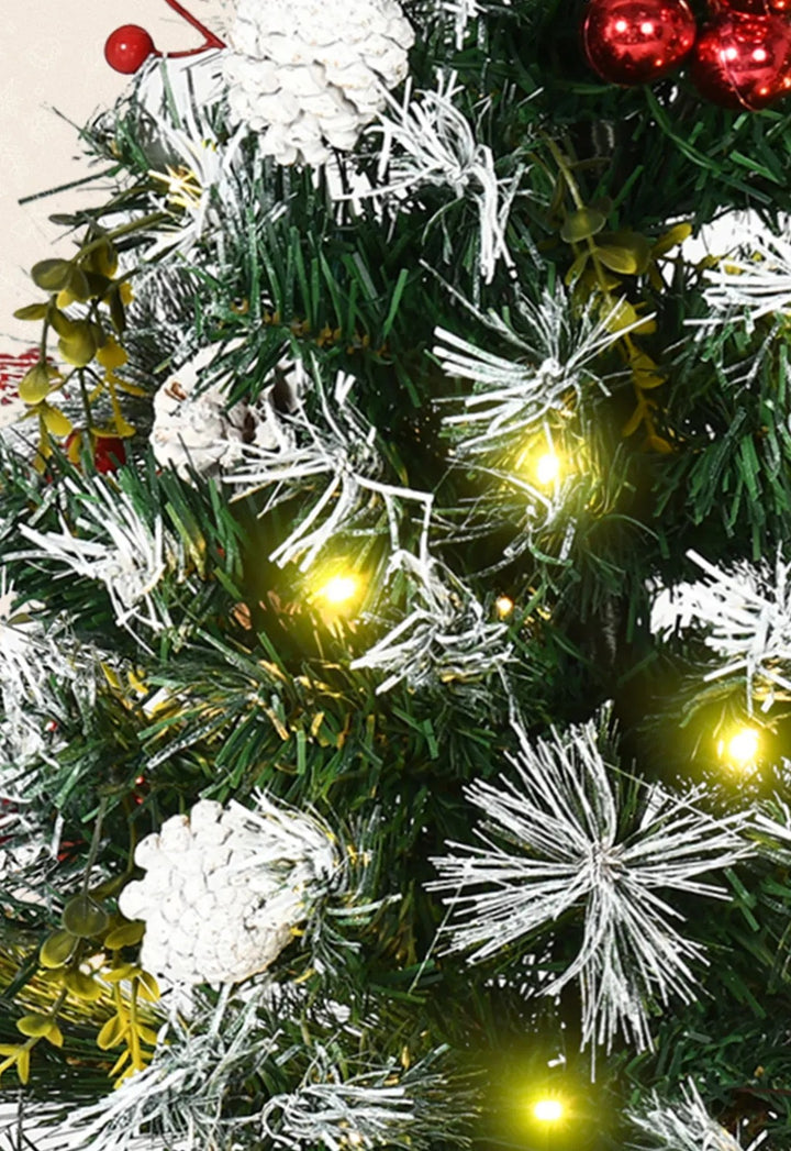 To små pyntede juletrær med lys ved døra