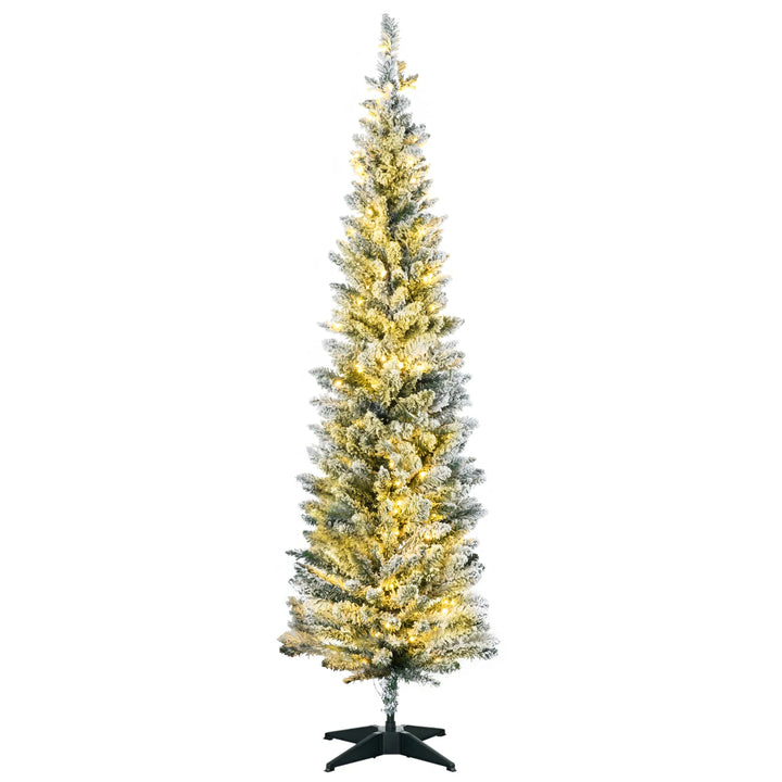 Smalt snødekt juletre med varmhvite lys i stue
